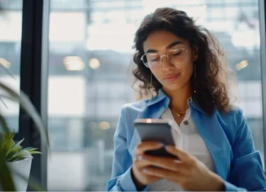 Empresária consultando o celular no escritório