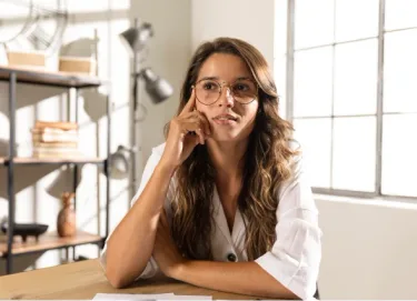 Mulher pensativa em um ambiente de trabalho iluminado